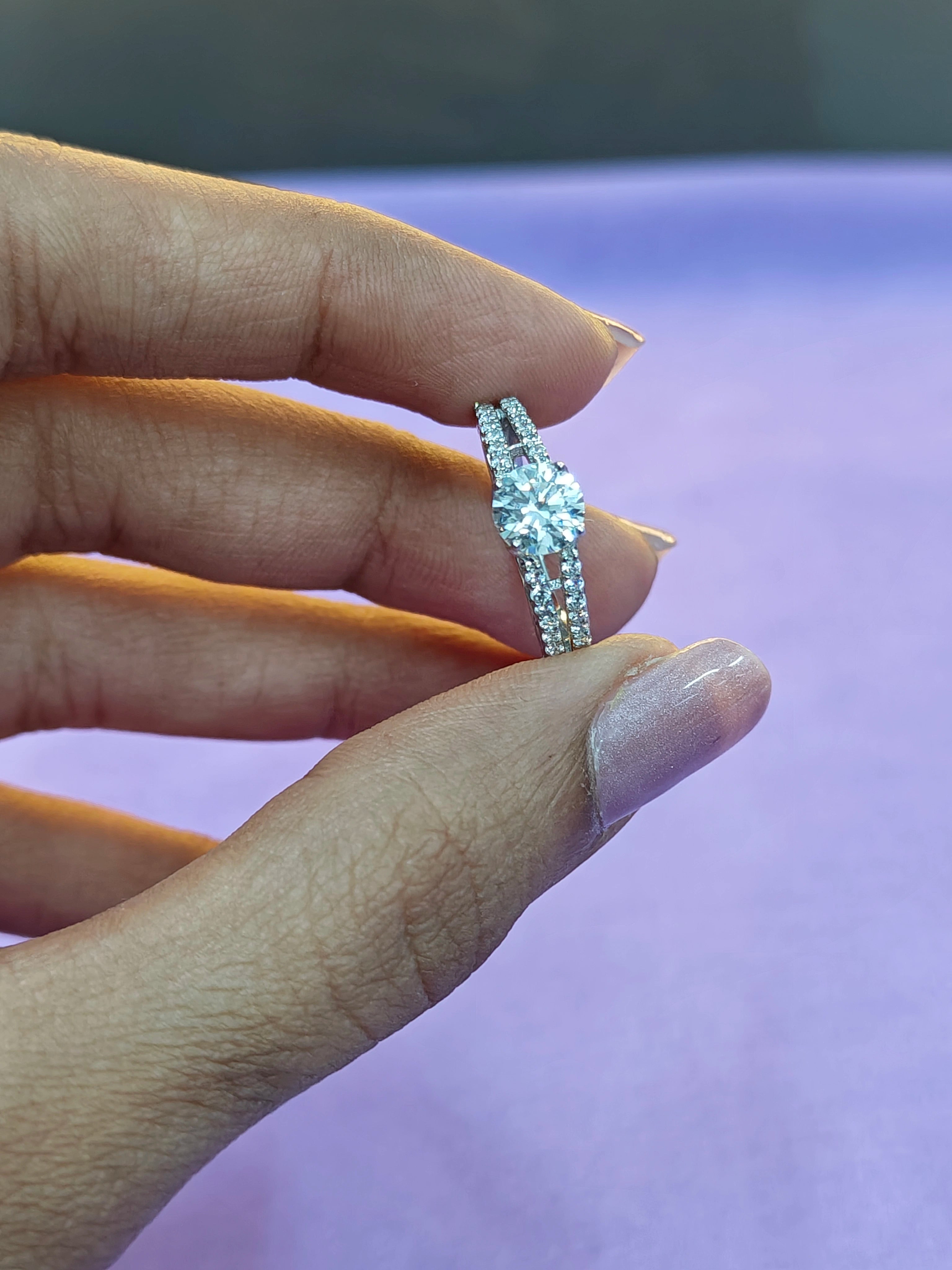 Hand wearing a diamond ring with a blurred background